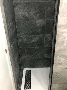 塔拉韦拉·德·拉·雷纳Casita tranquila的带淋浴的浴室和黑色瓷砖墙