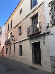 马拉加Málaga Apartamentos - Jinetes, 23的街道上设有窗户和阳台的建筑