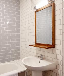 纽尼顿Chase Inn By Greene King Inns的浴室配有盥洗盆、镜子和浴缸