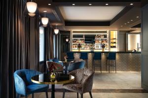 卡利亚里Palazzo Doglio的餐厅设有酒吧,配有蓝色的桌椅