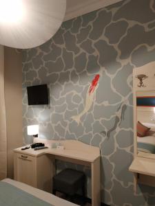 卡莫利La Camogliese Hotel B&B的一间卧室配有书桌和壁画