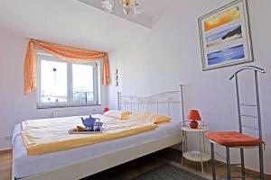诺伊霍夫Villa Seestern _ Wohnung 10的一间卧室设有一张床和一个窗口