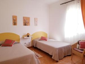 阿格特Casa Camino Tamadaba的客房设有两张床、一把椅子和窗户。