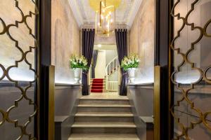 伊斯坦布尔The Soul Istanbul Hotel的走廊上设有楼梯,配有吊灯和鲜花