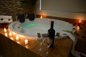PichanakiHotel Monte Cafeto INN的浴缸内的一瓶葡萄酒和酒杯