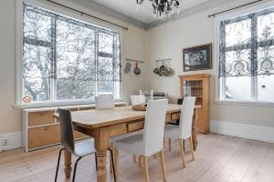 雷克雅未克Sudurgata - Authentic Reykjavik Style Apartment的一间带木桌和白色椅子的用餐室