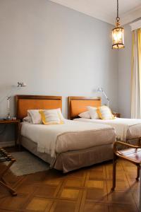 瓦尔帕莱索泽罗酒店的配有两张桌子和两盏灯的房间的两张床