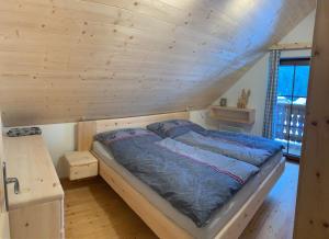 FlattnitzAlmhaus & Almchalet Flattnitz的木天花板的客房内的一张床位