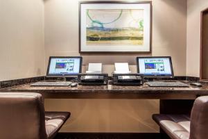 拉瓦尔拉瓦尔蒙特利尔假日酒店的一张桌子,上面有三台笔记本电脑