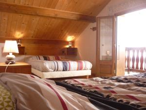 PlanayChalet Analma的一间卧室设有两张床和木制天花板