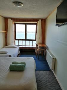 弗鲁蒂亚尔Laguneclub - Su casa de campo的客房设有两张床、一张桌子和一个窗户。