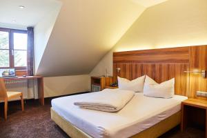 伊斯马宁Hotel Restaurant Erber的一间卧室配有一张大床和木制床头板