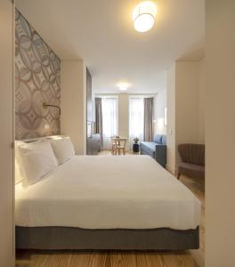 里斯本Lisbon Serviced Apartments - Santos的卧室配有一张白色的大床和一张沙发。