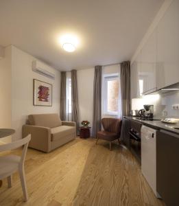 里斯本Lisbon Serviced Apartments - Santos的带沙发的小客厅和厨房