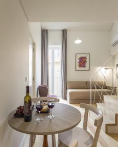 里斯本Lisbon Serviced Apartments - Santos的客厅配有桌子和两杯葡萄酒