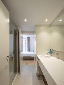 里斯本Lisbon Serviced Apartments - Santos的一间带大镜子和盥洗盆的浴室