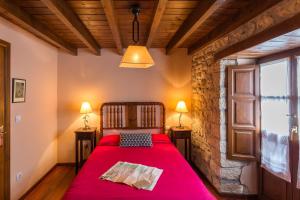 坎加斯-德奥尼斯Casas Rurales Pandesiertos的一间卧室配有一张红色的床和两盏灯