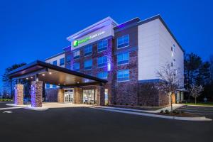 伍德斯托克Holiday Inn Express & Suites Atlanta N - Woodstock, an IHG Hotel的夜间酒店外墙的 ⁇ 染