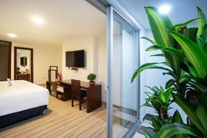 伊皮亚莱斯Loft Hotel Ipiales的一间卧室配有一张床、一张书桌和一台电视。