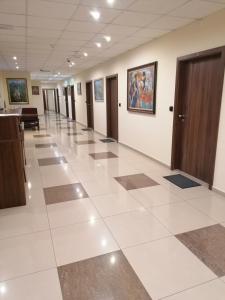 佩什泰拉Hotel Lago Peshtera的办公室大楼的走廊,铺着大型瓷砖地板