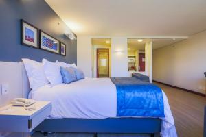 巴西利亚舒适巴西利亚套房酒店的一间卧室配有一张大床和一张桌子