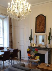 布尔日Calme et au cœur du centre historique的客厅配有吊灯和桌椅