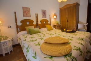 Aldea de Trujillo卡萨厄尔特纳多乡村民宿的一间卧室配有一张大床,上面有帽子