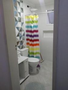 卡拉瓜塔图巴Riviera Massaguaçu 23的浴室设有卫生间和彩虹浴帘