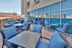 普莱诺Holiday Inn Express & Suites Plano East - Richardson, an IHG Hotel的大楼内带桌椅的天井