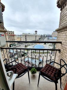 基辅Inn Home Apartments in Kiev Center的阳台配有两把椅子,享有游泳池的景色