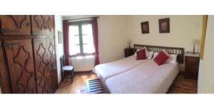 贝纳斯克Casa el Roso的一间卧室配有一张带两个红色枕头的床