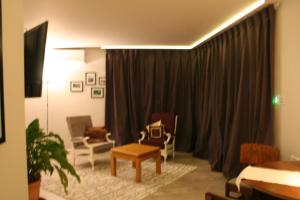 WaimateAHAVA Bed & Breakfast的客厅配有沙发、椅子和窗帘