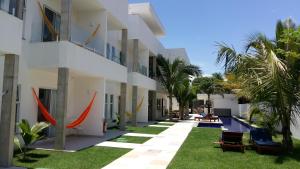 卡姆布库KiteBar Hotel的享有带草和棕榈树的建筑的外部景色