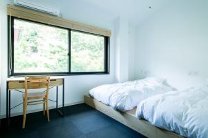 京都雅朵岚山酒店的一间卧室配有一张床、一张书桌和一个窗户。