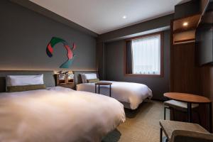东京东京羽田日航城市酒店 的酒店客房设有两张床和电视。