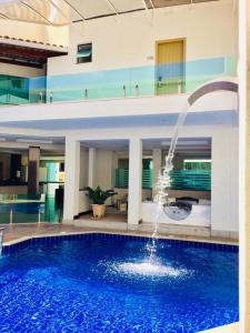 塞古罗港MIRAGE HOTEL的一座大型游泳池,在一座建筑中设有喷泉