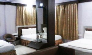 科鲁鲁Abimon Residency Kollur的酒店客房,设有两张床和镜子
