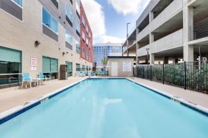 法默斯布兰奇Holiday Inn Express & Suites Dallas NW - Farmers Branch, an IHG Hotel的一座建筑的庭院里的一个大型游泳池
