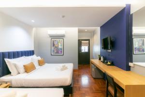曼谷Castle Black Bangkok的酒店客房配有两张床和一张书桌