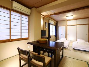 东京浅草加茂川日式旅馆 的客房设有书桌、床、桌子和椅子。