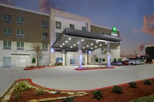 查尔斯湖Holiday Inn Express & Suites - Lake Charles South Casino Area, an IHG Hotel的酒店停车场设有加油站,配有灯