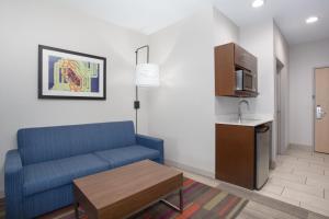 阿马里洛Holiday Inn Express & Suites Amarillo, an IHG Hotel的一间带蓝色沙发的客厅和一间厨房