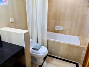 哥打京那巴鲁唐代酒店的浴室配有白色卫生间和浴缸。
