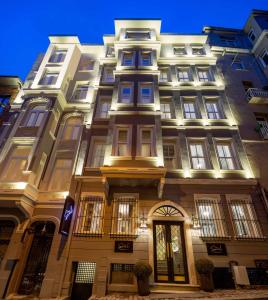 伊斯坦布尔The Soul Istanbul Hotel的一座高大的建筑,旁边灯火通明