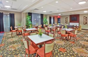 卡明亚特兰大 - 卡明智选假日套房酒店的用餐室配有桌椅