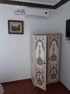 舍夫沙万Casa El Haouta的一间墙上挂有绘画的白色墙壁客房