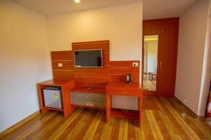 蒙纳The Lake View Munnar Resort的客房设有一张木桌和一台电视机