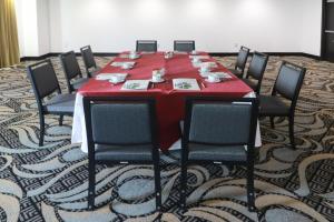 克雷塔罗克雷塔罗卵克里斯塔尔假日酒店的一张桌子,一张桌子,一张桌子,一张椅子和一张红色的桌子