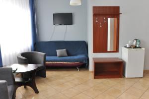 比得哥什埃尔达2号酒店的客厅配有蓝色的沙发和桌子