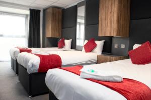泰恩河畔纽卡斯尔Hotel Express Newcastle Gateshead的酒店客房 - 带4张带红色枕头的床